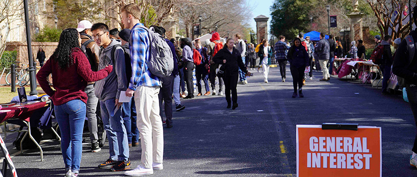 Students talk at a student organization fair on Greene street, in front of Russell House.