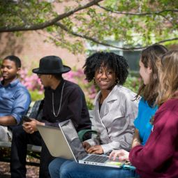 Group of students sitting together with laptops