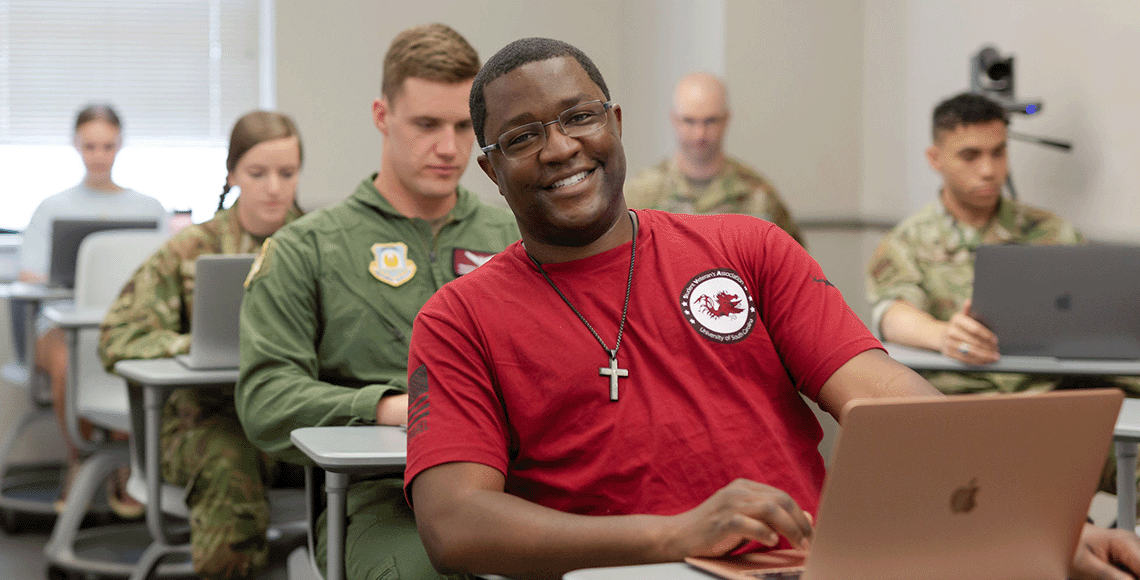 Student veteran sitting in a classroom smiling