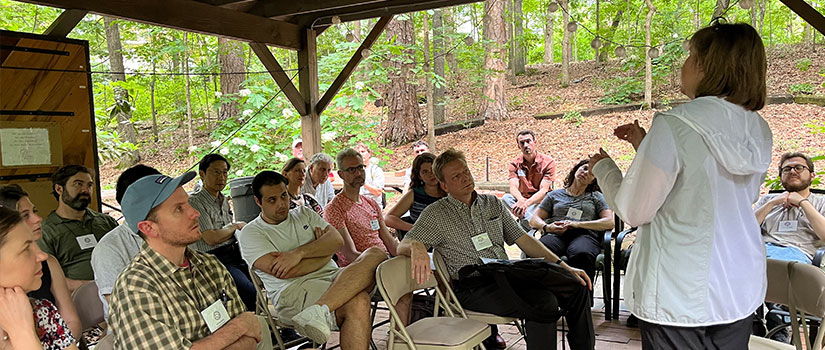 group of people listening to an outdoor speaker