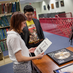 Student examining a guitar from the band Kiss. 