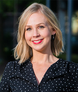 woman with blonde hair and a navy poka dot blouse on