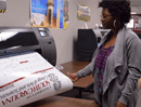 A young woman prints a large poster