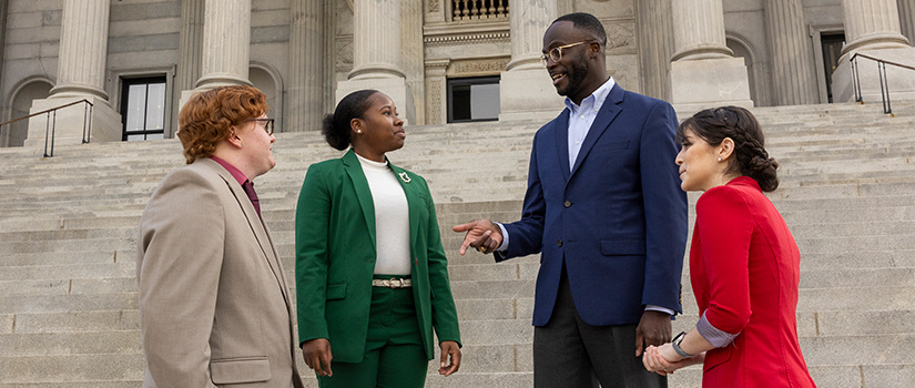 group of students at the statehouse meeting with public official alum