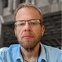 photo of man in blue shirt with glasses