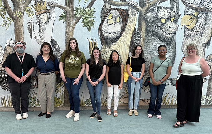 students standing in front of Where the Wild things are at the library