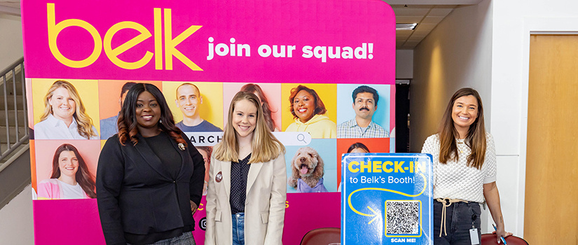 Three recruiters from Belk pose for a photo at their table while attending the 2023 Experience Expo at Colonial Life Arena.