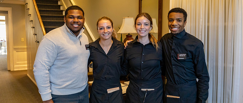 Four students pose for a photo inside McCutchen House.