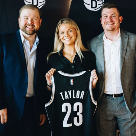 Kellie Taylor holding #23 jersey with her name on the back