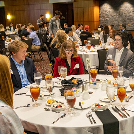 Students enrolled in HRSM 301 talk among themselves at a business etiquette dinner seminar.