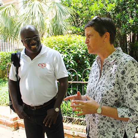 Robin DiPietro speaks to a group of individuals while one person smiles in the background.