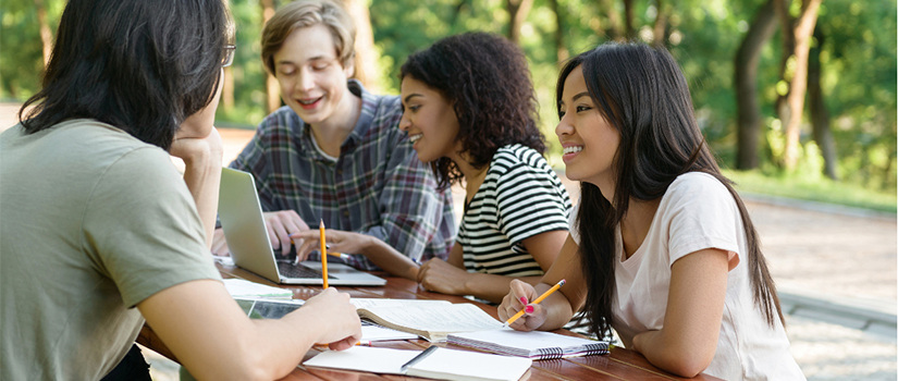 Group of students studying outside at a table