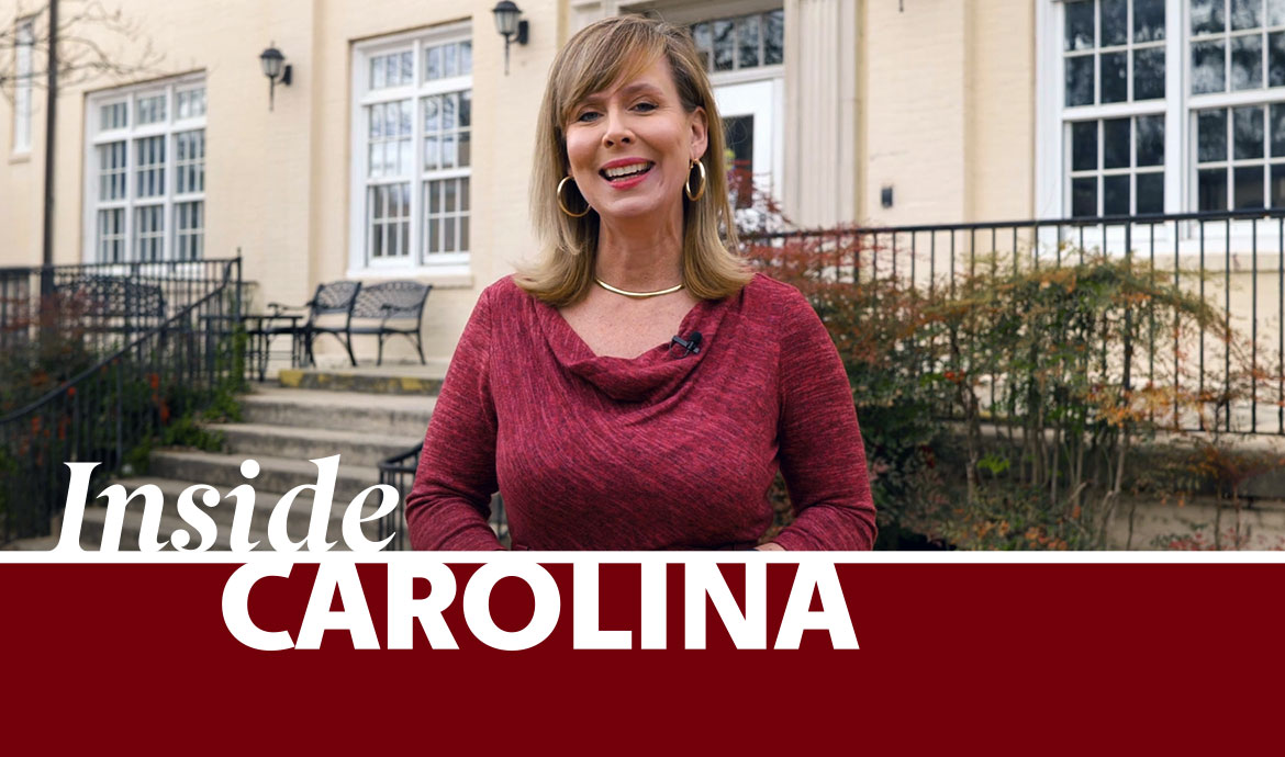 woman stands in front of a building with a graphic that reads inside Carolina on top of the photo