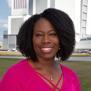 Woman standing in front of the Kennedy Space Center. 