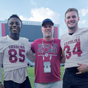 Stephen Panus, center, poses with the 2022 scholarship winner, wide receiver Payton Mangrum (left), and the 2021 winner,  long snapper Matthew Bailey.