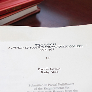 Pages of a thesis document amid stacked books
