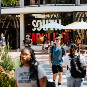 students walking past a university of south carolina sign