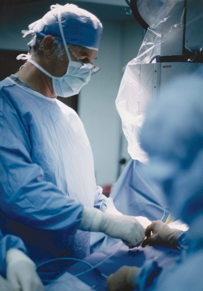 Eddie Floyd in scrubs performing an operation.